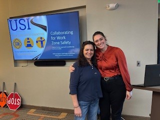 two women standing by PowerPoint slide