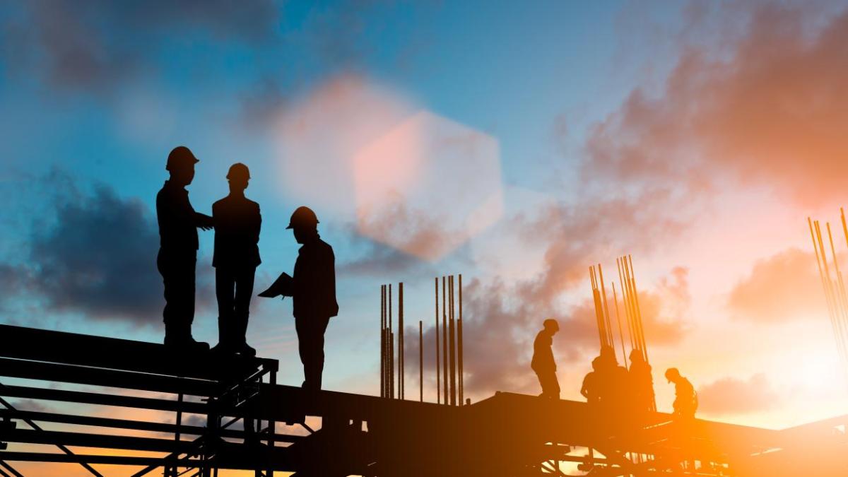 Construction workers at sunset