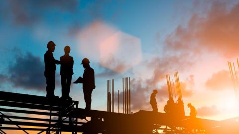 Construction workers at sunset